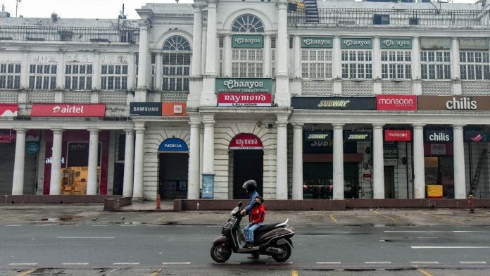 A man drags his scooter as his child is seen sitting on it at a deserted Connaught place during the weekend curfew in New Delhi, on 9 January 2022 | Representational image | ANI photo