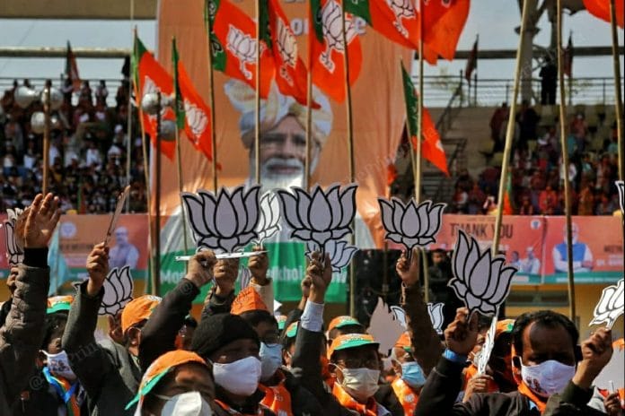 Supporters carry lotus in the rally | Photo: Praveen Jain | ThePrint
