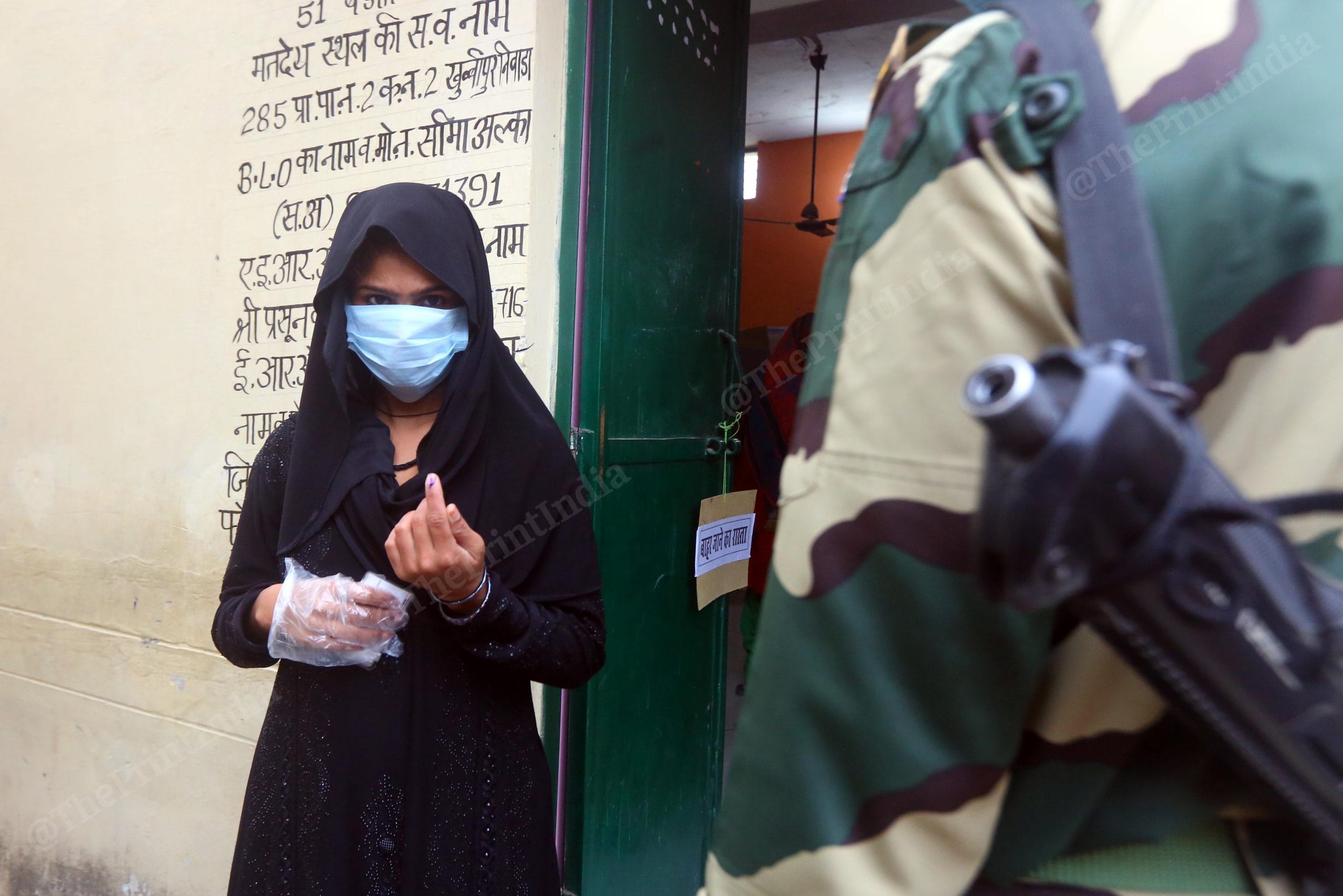 A woman stands outside a polling booth in Nethla village in Baghpath district, after casting her vote | Praveen Jain | ThePrint