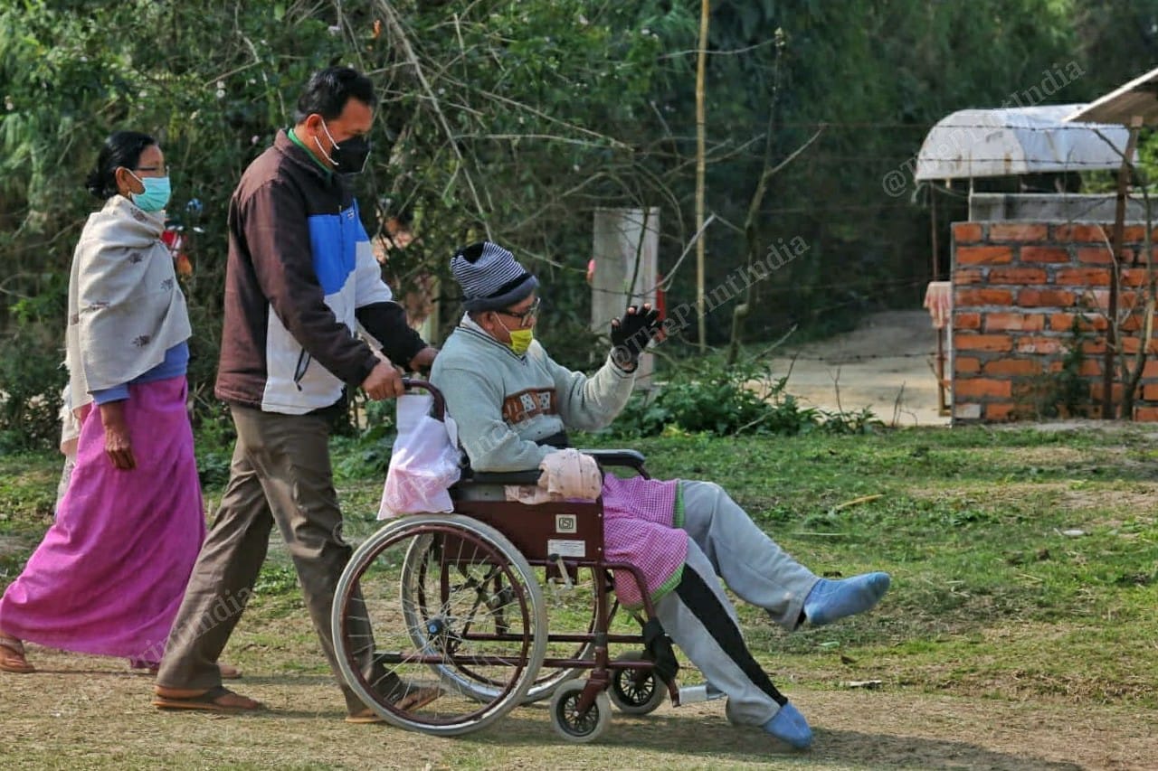 Family member taking his physically disabled relative to cast their vote at Takhel primary school in Lamlai constituency | Praveen Jain | ThePrint