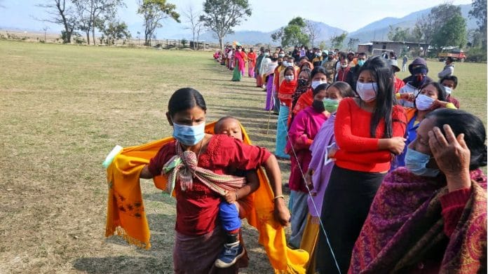 Women with he child line up in a side of the que outside the polling booth in Lumlai assembly constituency in phase 1 of Manipur polls | Praveen Jain | ThePrint