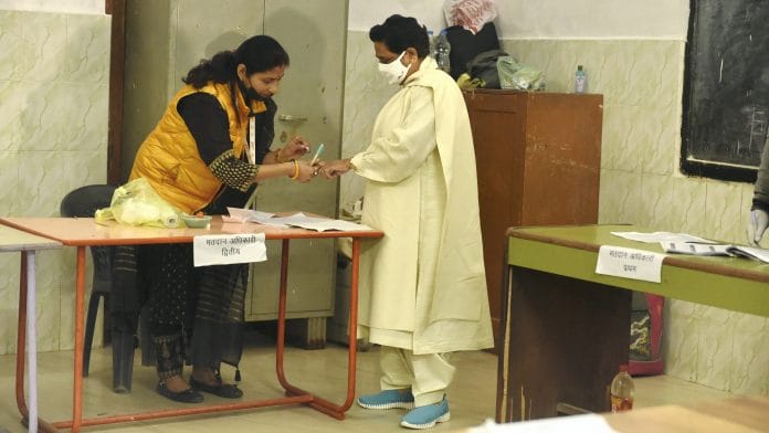 BSP supremo Mayawati gets her finger marked with indelible ink as she prepares to cast her vote in Lucknow on 23 February 2022 | PTI Photo