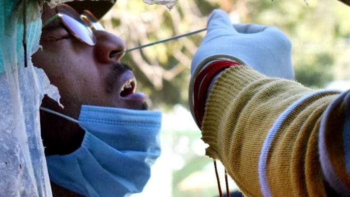 A healthcare worker collects nasal swab sample of a man for Covid-19 test, at a testing centre, in Prayagraj on 9 February 2022 | Photo: ANI