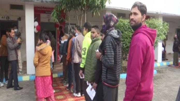 People wait outside a polling booth in Uttarakhand to cast their votes on 14 February 2021| Twitter/ani_digital