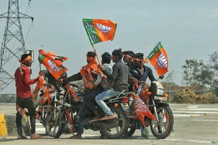 Supporters of BJP carry flags during a rally | Photo: Praveen Jain | ThePrint