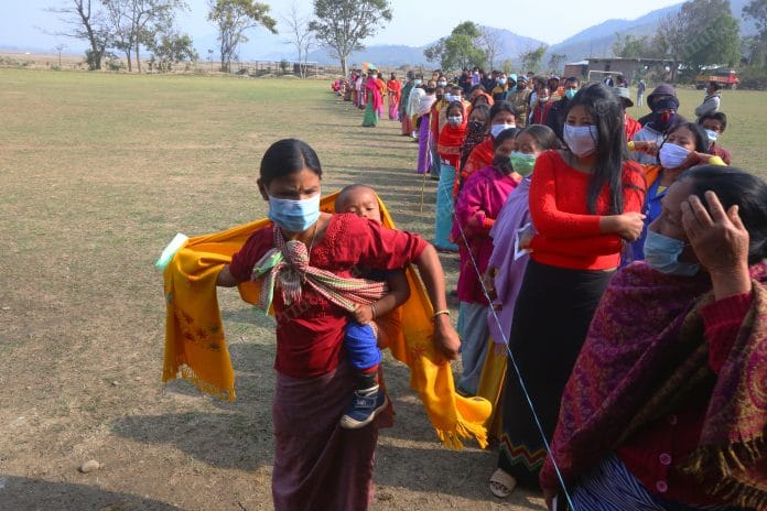 Women with he child line up in a side of the que outside the polling booth in Lumlai assembly constituency in phase 1 of Manipur polls | Praveen Jain | ThePrint