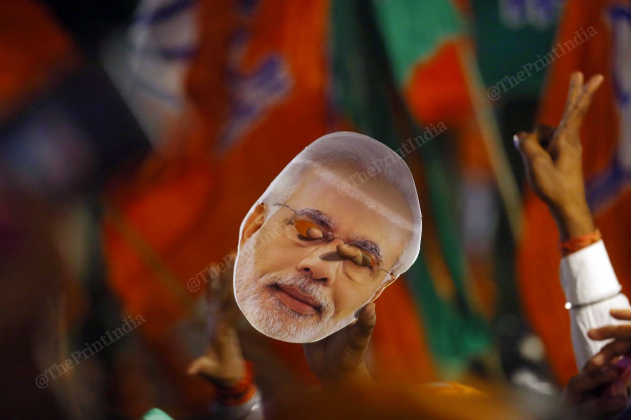 BJP's four-state election victory is a revalidation of the power of 'Brand Modi'. A supporter pays homage by holding up a 'Modi mask' | Photo: Praveen Jain | ThePrint
