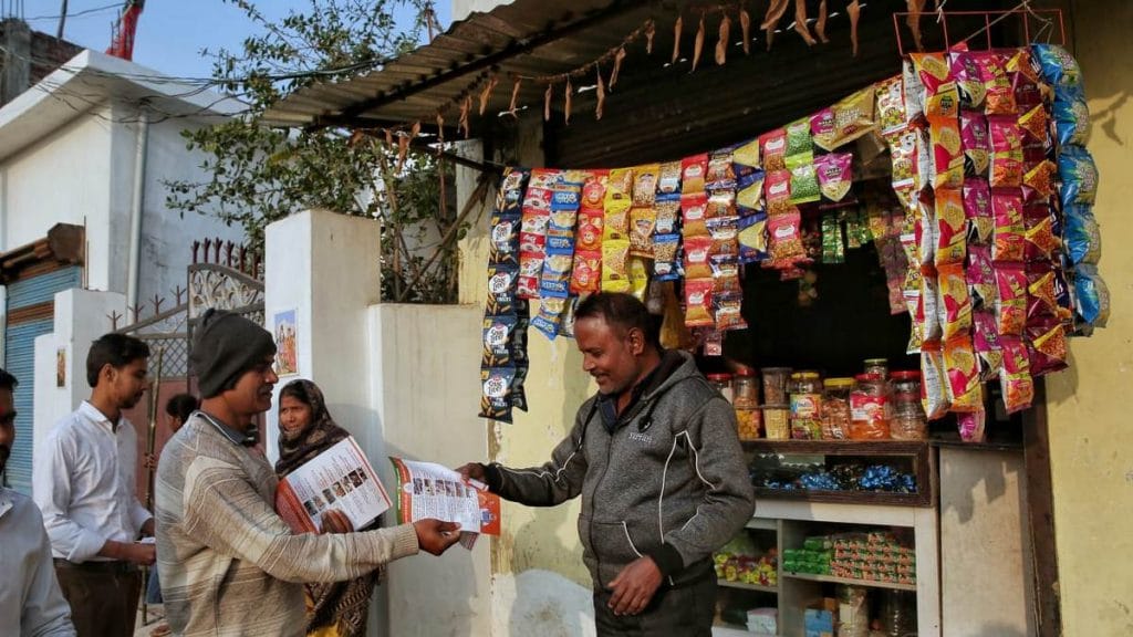 An RSS worker distributes pamphlets during a door-to-door campaign in Moharipur, Gorakhpur | Suraj Singh Bisht | ThePrint