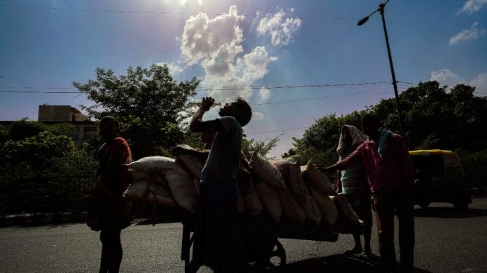 Labourers push a cart as one drinks water to survive the scorching heatwave in New Delhi | Representational image | ANI