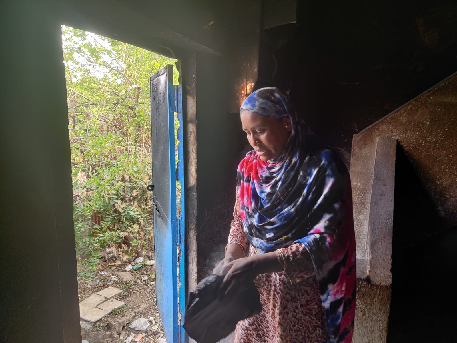 Aisha Khan flips through the burnt pages of the Quran. | Photo: Bismee Taskin | ThePrint