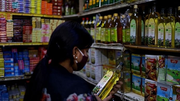 A customer browses bottles of cooking oil at a store on the outskirts of New Delhi | Bloomberg