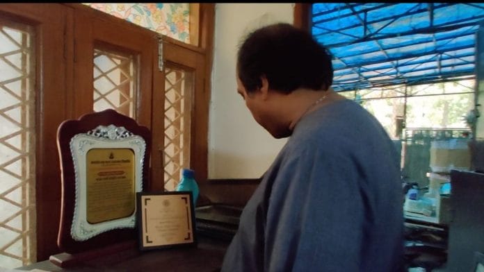 Singer Wasifuddin Dagar looks at his awards and citations as he packs to leave the government accommodation | Photo: Reeti Agarwal