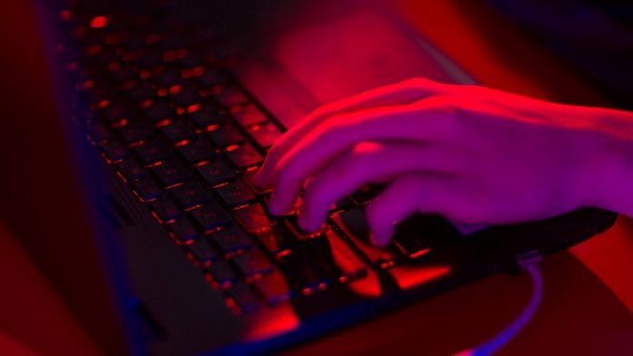 Red light illuminates the keys of a laptop | Representational image | Photo via Bloomberg