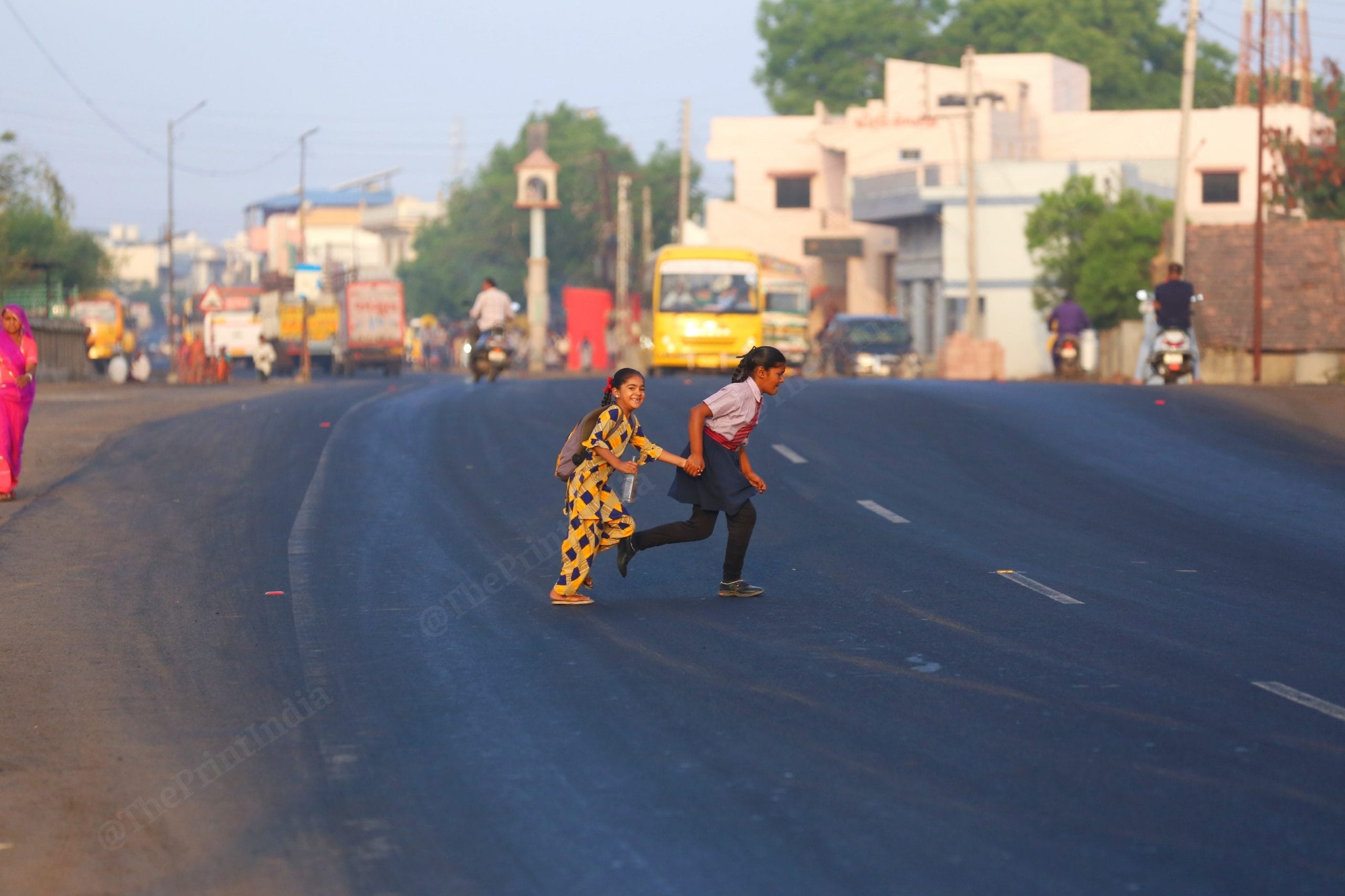 Two children run across the road in Kachchh, as the school bell rings to indicate the start of school | Photo: Manisha Mondal | ThePrint