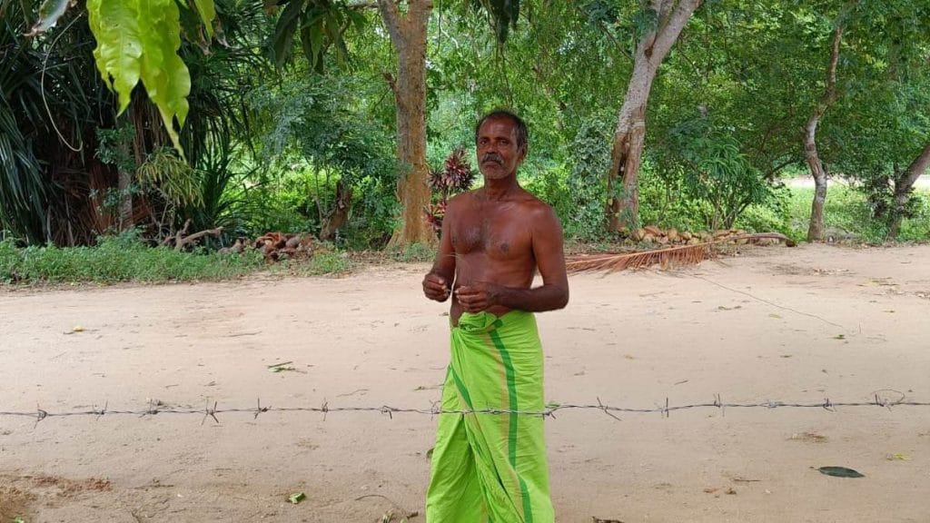 Farmer A.G. Dharmasiri mends a barbed wire fence to keep elephants out of his farm in Walsapugala village | Sowmiya Ashok | ThePrint