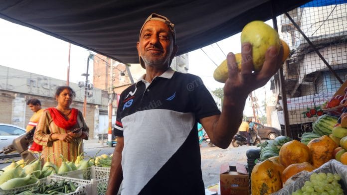 Abdul Rashid Malik, father of SunRisers Hyderabad's pace bowling sensation Umran Malik, holds up fruits at his stall in Jammu | Photo: Praveen Jain | ThePrint
