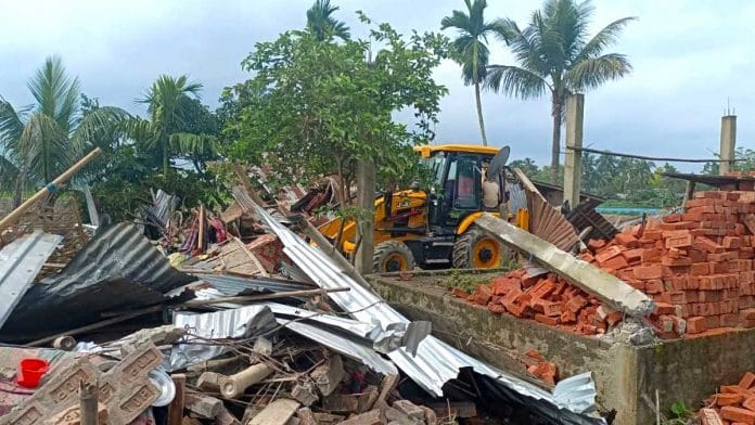 A bulldozer demolishes the house of a relative of a man who reportedly took part in burning Batadrava Police station | Photo: ANI