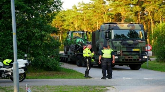 Dutch security personnel purportedly towing away a protesting farmer's tractor | Twitter | @oryxspioenkop