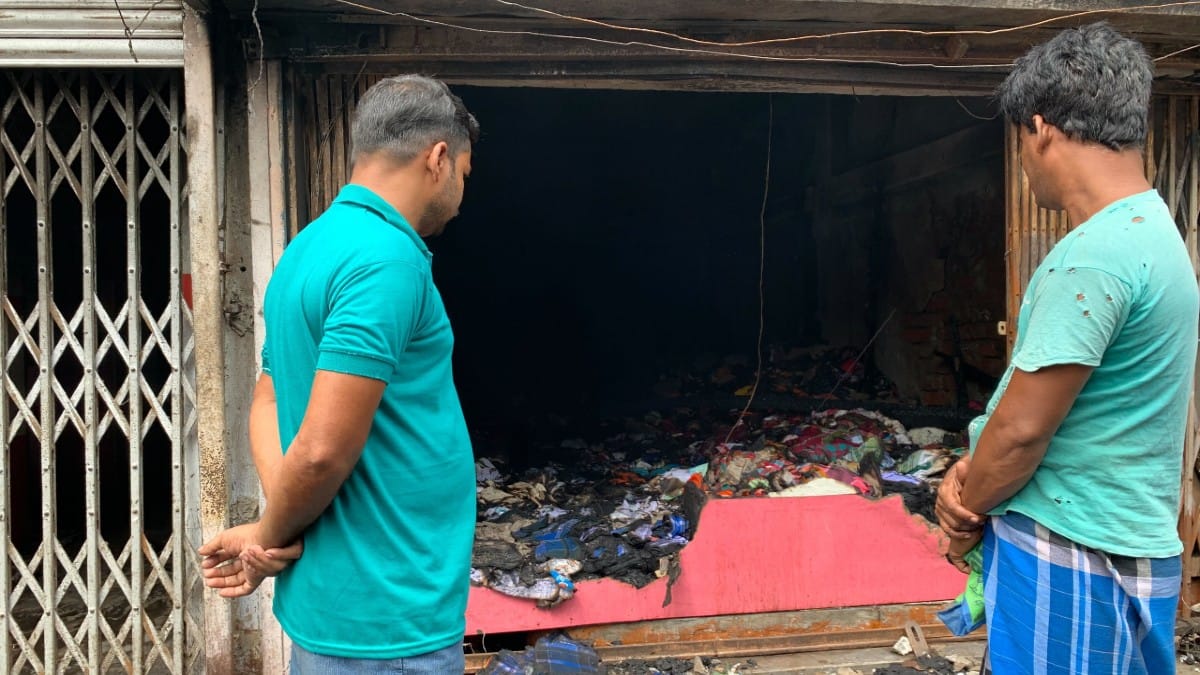 Bystanders outside a charred garment shop in Panchla market | Sreyashi Dey | ThePrint