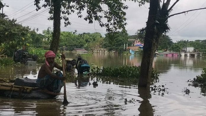 A man wades through a flooded neighbourhood in his makeshift boat at Singari village | Angana Chakrabarti | ThePrint