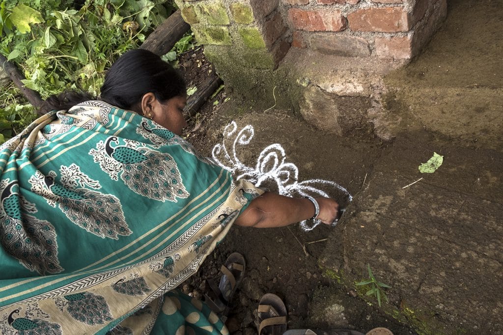 The sole teacher Shital More starts the class by drawing rangoli at the entrance of the school. She teaches the students how to sign their names, read in Marathi and multiply | Jayati Saha