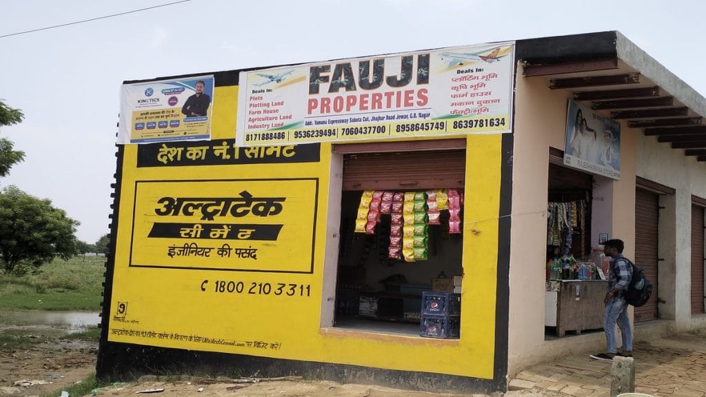 A flex board with a flight for selling land around the airport | Tina Das | ThePrint