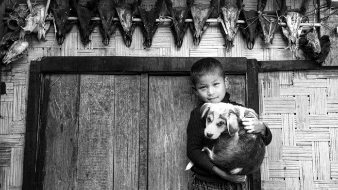 A hunter's son cuddles his dog. | Photo Credit: Asha Thadani