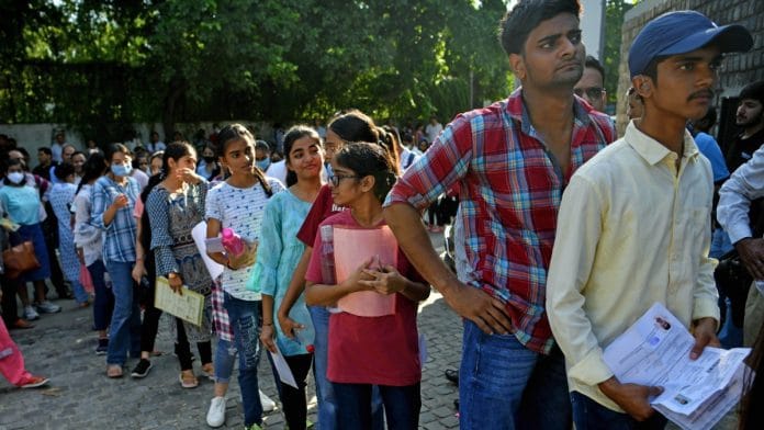 Aspirants wait in a queue to appear for CUET at a centre in Delhi | ANI file photo