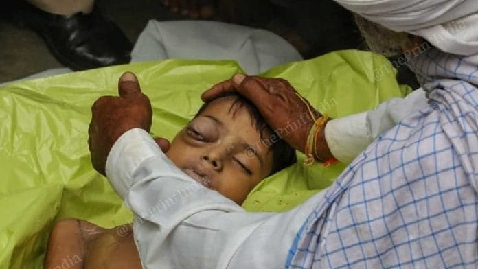 Pola Ram, Indher Meghwal's grandfather, touching his grandson's face, in Jalore | Photo: Praveen Jain | ThePrint