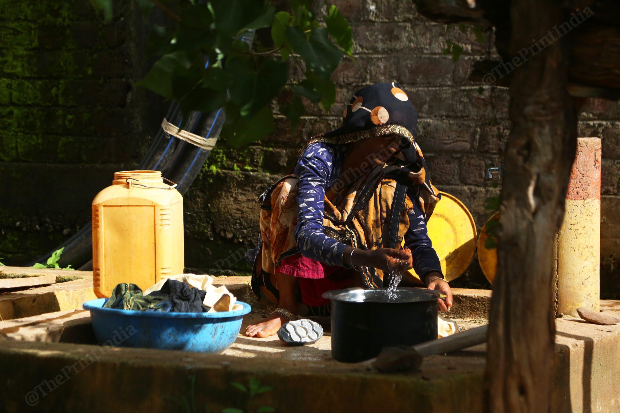 A woman washes clothes on the platform built by the government to save water | Manisha Mondal, ThePrint