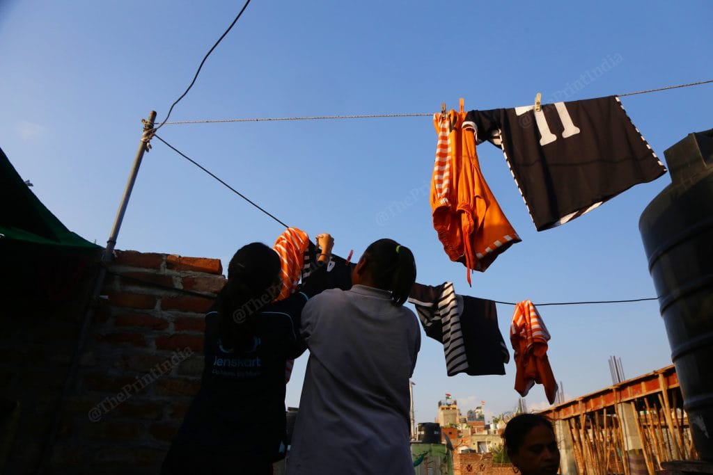 Girls are really emotional about their jerseys. The new jerseys had printing mistakes which had upset a few of them. But they managed to salvage it by using paint brushes and colors. Jerseys are now left for drying up | Photo: Manisha Mondal | ThePrint