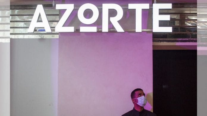 An employee wearing a face mask stands outside the Azorte, a fashion and lifestyle store of Reliance Industries, during its launch in Bengaluru, on 29 September 2022 | Reuters