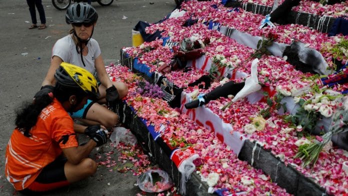 A woman comforts a man as they pay condolence to the victims after a riot and stampede following soccer match between Arema vs Persebaya, outside the Kanjuruhan stadium in Malang, East Java province, Indonesia | Reuters/Willy Kurniawan