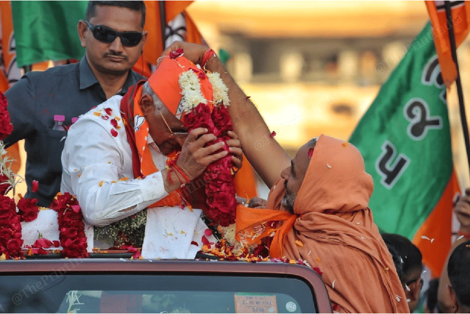 A monk greets CM with a garland | Photo: Praveen Jain | ThePrint