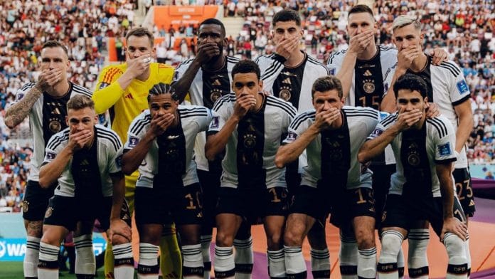 Germany players cover their mouths as they pose for a team group photo ahead of their game against Japan, on 23 November 2022 | Image via Twitter/@DFB_Team_EN