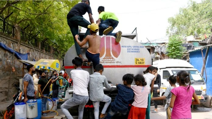 File photo of people collecting potable water from a tanker provided by MCD in New Delhi | ANI