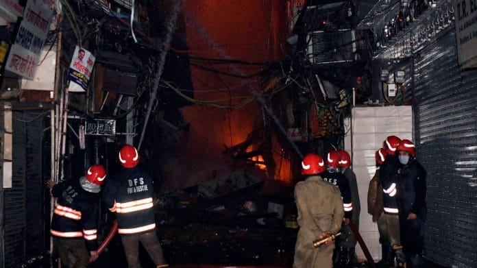 A team of firefighters spraying water as fire broke out in the shops of Bhagirath Palace market of Chandni Chowk, on 24 November 2022 | ANI