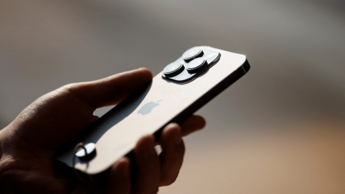 A man holds an iPhone 14 as Apple Inc's new models go on sale at an Apple store in Beijing, China | Reuters File Photo/Thomas Peter