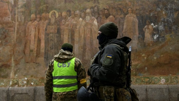 Ukrainian law enforcement officers stand next to an entrance to the Kyiv Pechersk Lavra monastery compound amid Russia's attack | Reuters file photo/Vladyslav Musiienko