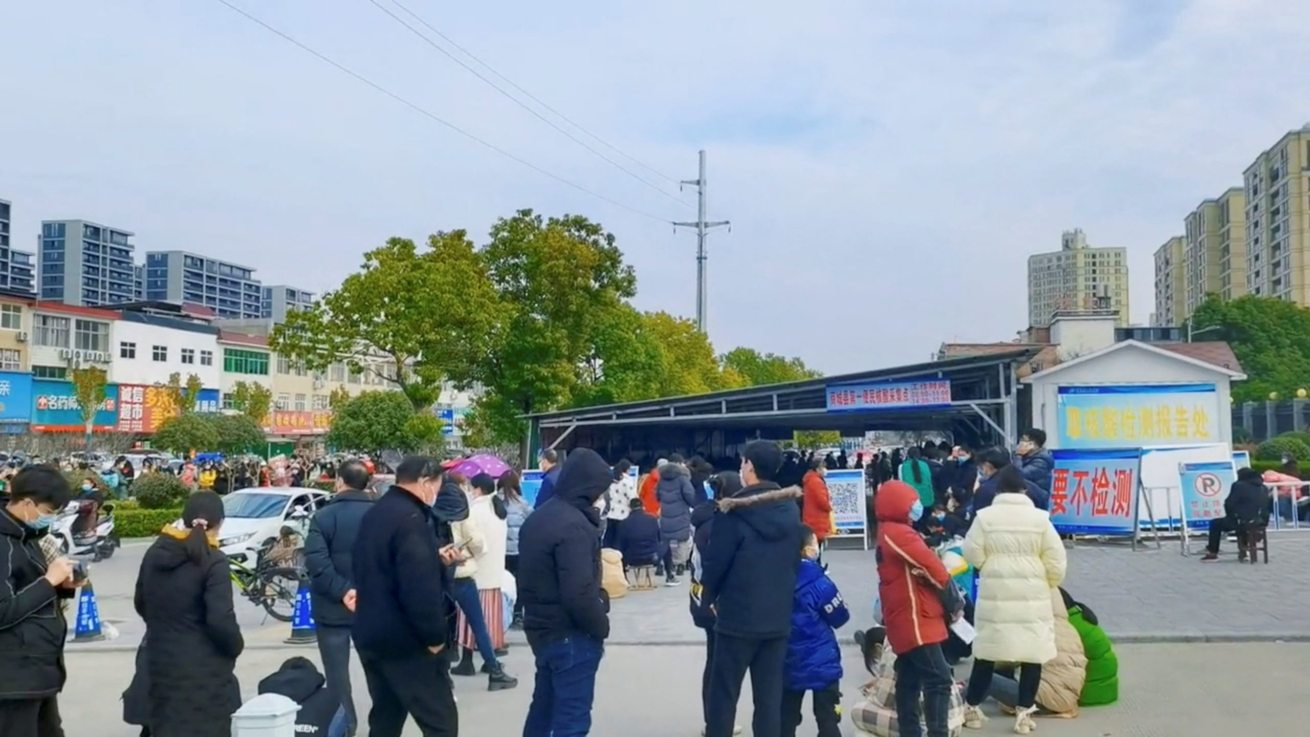 People wait in line at a coronavirus test centre in Xinyang, China | Video obtained by Reuters