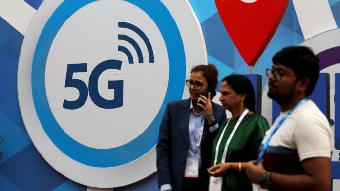File photo of people standing in front of a board depicting 5G network at the India Mobile Congress 2018 in New Delhi, India, 26 October 2018 | Reuters/Anushree Fadnavis