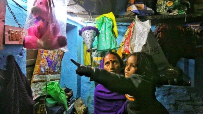 Four-year-old Shrishti, daughter of Mukesh Sharma who died of alcohol poisoning, with her grandmother at their home in Hanuman Ganj village, Bihar. She points to the toys her father gifted her | Credit: Praveen Jain, ThePrint