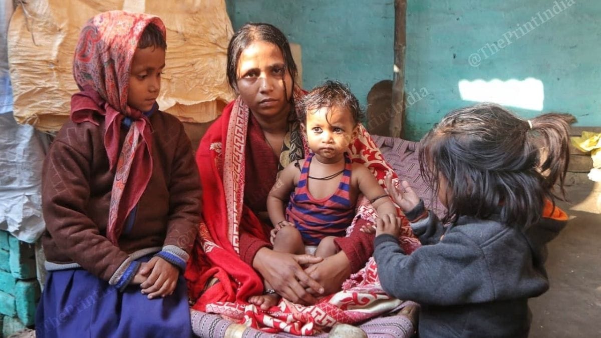 Pooja Devi, wife of Mukesh Sharma, with her daughters at her home in Hanuman Ganj village | Credit: Praveen Jain, ThePrint