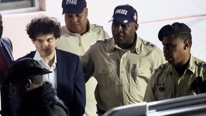 Sam Bankman-Fried, who founded and led FTX until a liquidity crunch forced the cryptocurrency exchange to declare bankruptcy, is escorted out of the Magistrate Court building after his arrest in Nassau, Bahamas | Reuters/Dante Carrer