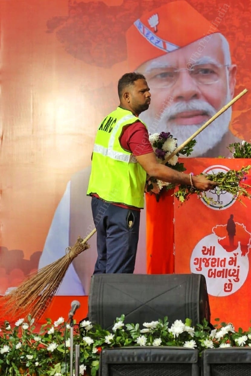 A sanitation worker cleans the stage with the broom before the arrival of BJP leaders | Photo: Praveen Jain | ThePrint