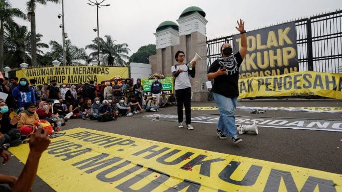 An activist shouts slogans during a protest, as Indonesia is set to pass a new criminal code that will ban sex outside marriage, cohabitation between unmarried couples, insulting the president, and expressing views counter to the national ideology, outside the Indonesian Parliament buildings in Jakarta, Indonesia, 5 December 2022 | Reuters/Willy Kurniawan