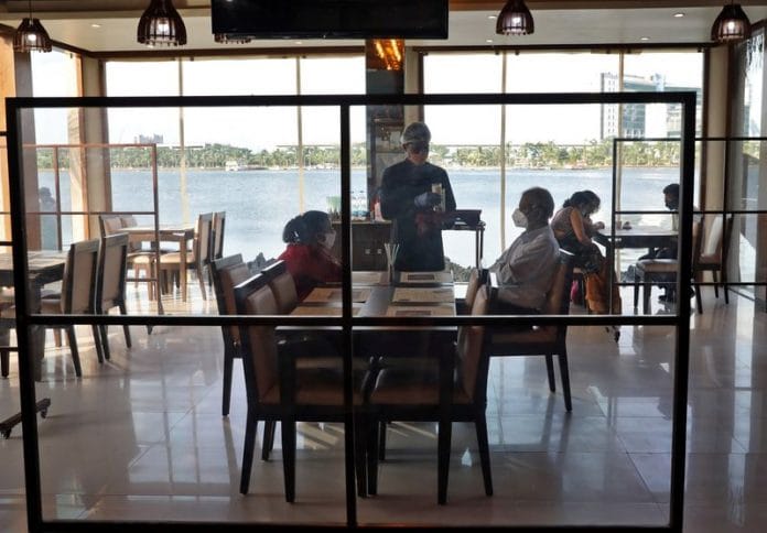 A waiter serving customers at the Cafe Ekante restaurant, after authorities eased lockdown restrictions that were imposed to slow the Covid-19, on the outskirts of Kolkata | Reuters/Rupak De Chowdhuri