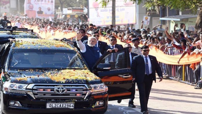 Prime Minister Narendra Modi waves at crowds during a roadshow, in Hubballi on Thursday. | ANI
