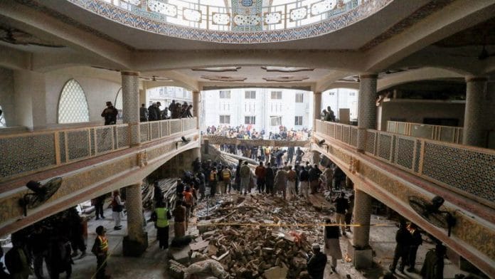 People and rescue workers gather to look for survivors under a collapsed roof, after a suicide blast in a mosque in Peshawar, Pakistan 30 January | Reuters