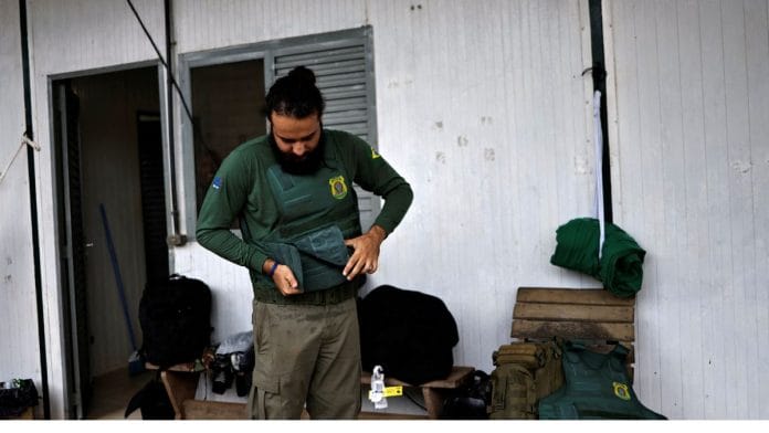 An agent of the Brazilian Institute for the Environment and Renewable Natural Resources (IBAMA) gets ready before going to an operation to combat of deforestation, in Uruara, Para State, Brazil on 19 January, 2023 | Reuters